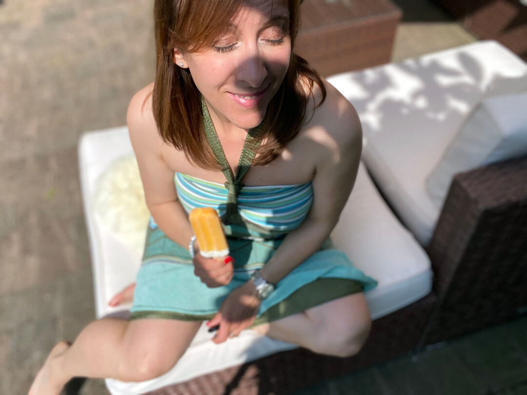 Frau sitzt mit einem Eis und geniesst die Sonne